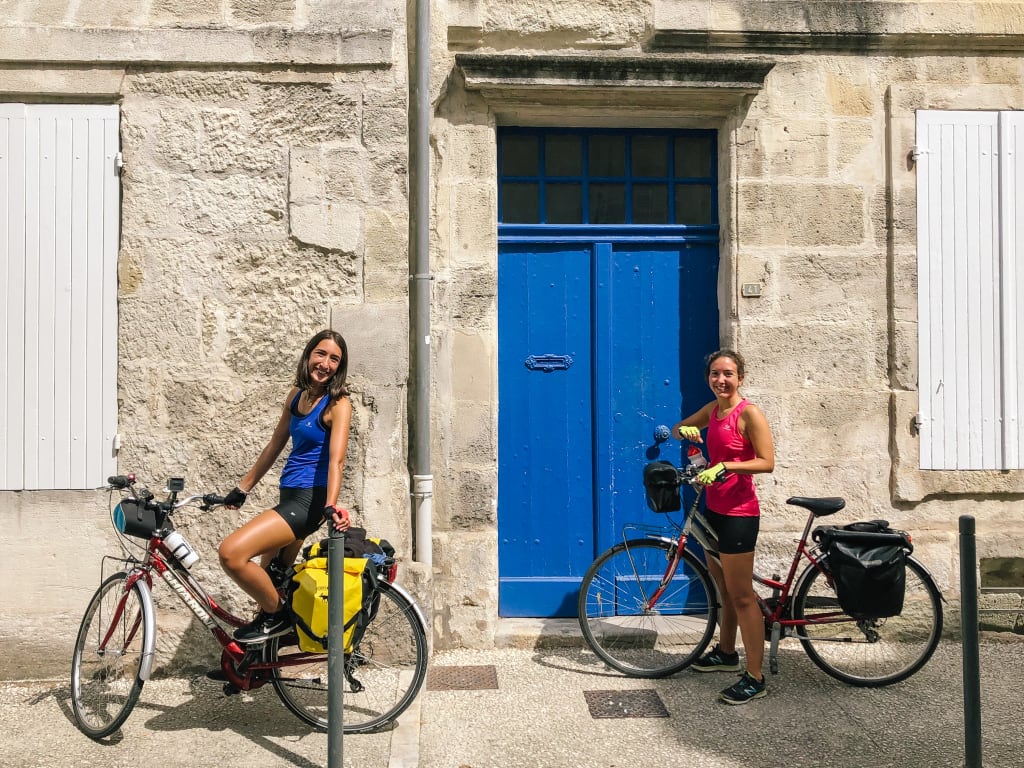 Ragazze in bici davanti ad un edificio tradizionale in un villaggio francese
